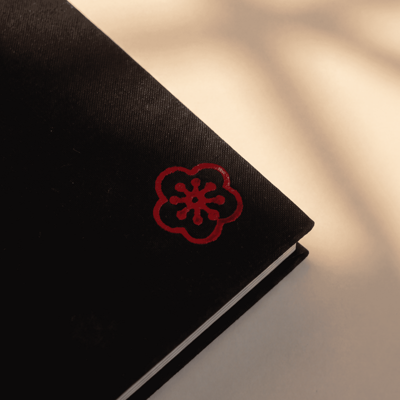 Customer logo mark — bottom-right of the cover, foil-stamped
